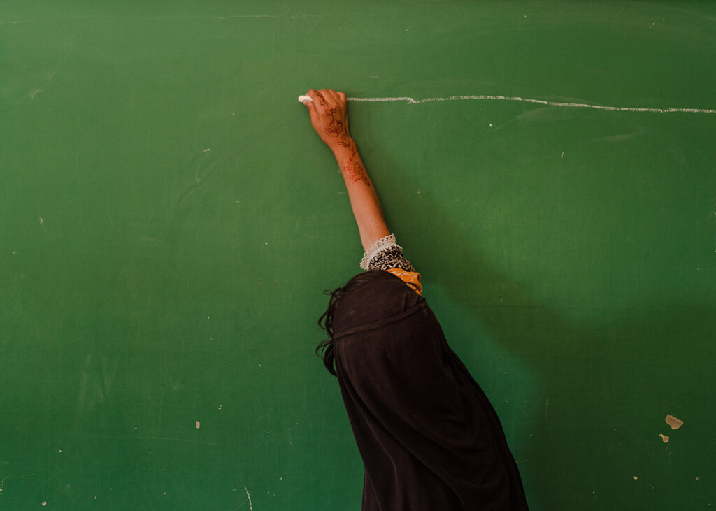Essere donna in Pakistan - Nafisa Shahzad, 10 anni, scrive alla lavagna nella scuola elementare TCF. La scuola TCF è nata su iniziativa di una ONG impegnata nel campo dell’istruzione femminile. Nafisa, che sogna di diventare medico, ha un padre gravemente malato e nel tempo libero aiuta la madre a casa. Le spese della sua istruzione sono interamente a carico della scuola. Nathoki, Lajore, Pakistan, 25 aprile 2024. 