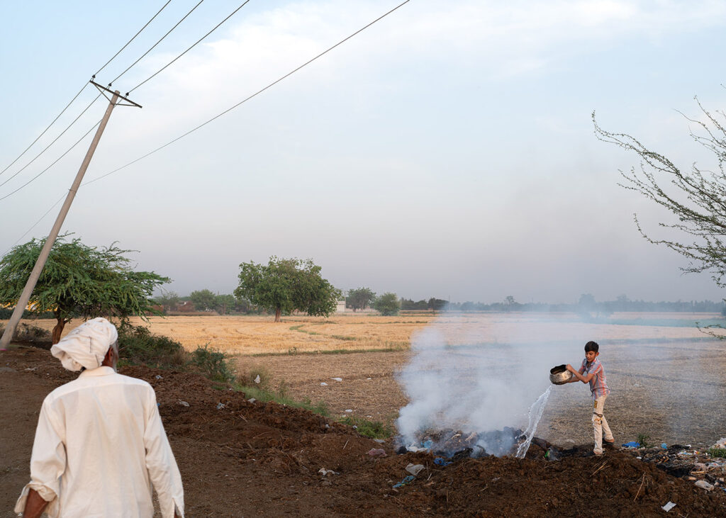 Essere donna in Pakistan - Al confine tra Pakistan e India un ragazzino spegne un incendio controllato. Lahore, Pakistan, 25 aprile 2024.