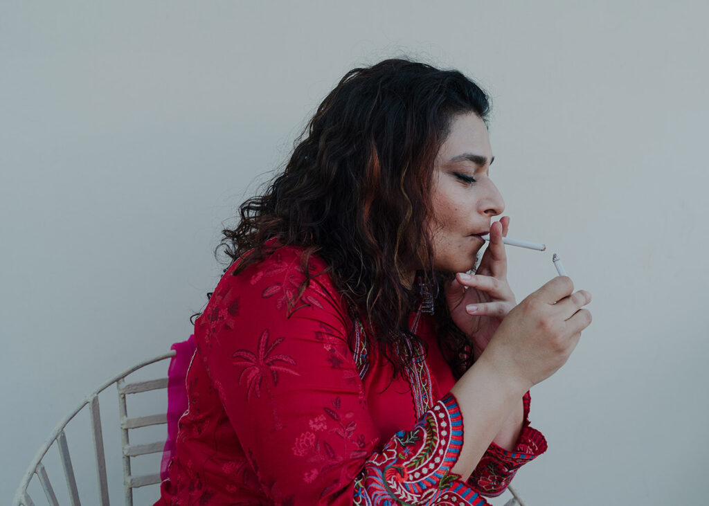 Essere donna in Pakistan - Kena Tarek, 40 anni, si accende una sigaretta dopo le prove di ballo di un matrimonio. Karachi, Pakistan, 11 aprile 2024.