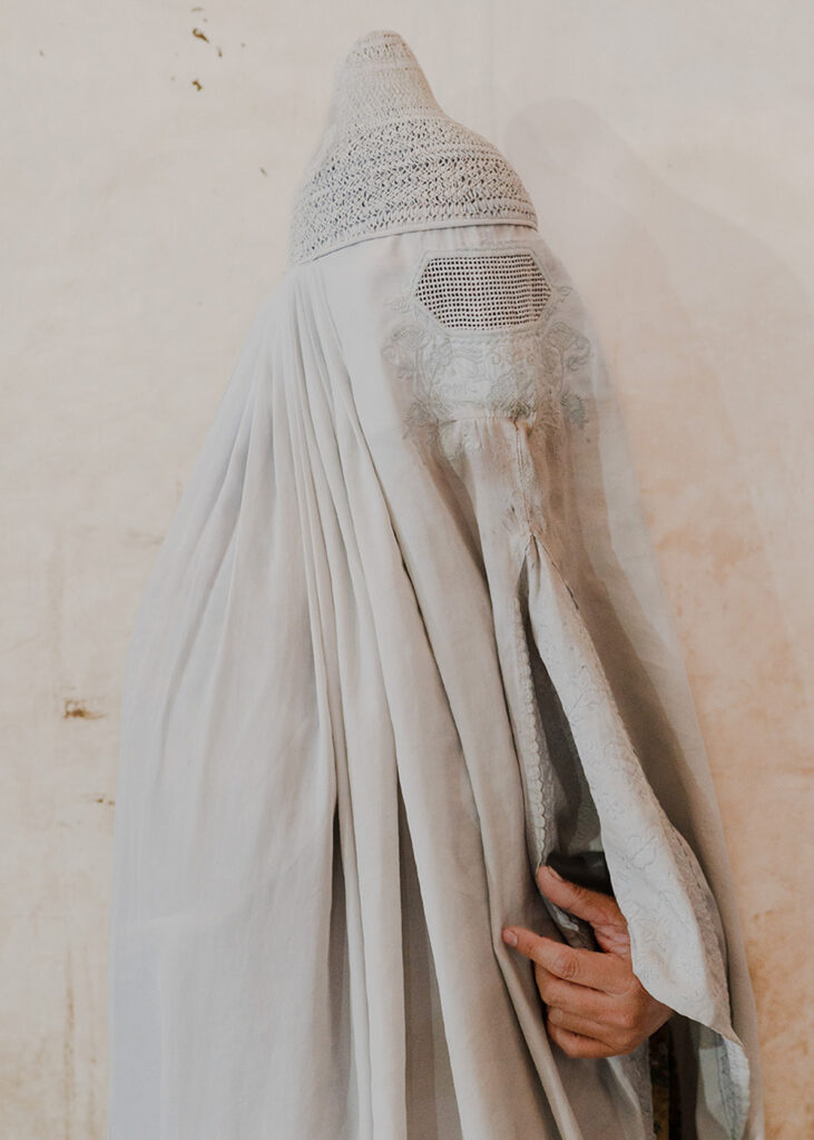 Essere donna in Pakistan - Ritratto di Kousar mentre indossa il burqa. Kousar e la sua famiglia si sono recati alla tomba di Hazrat Zakarya a Multan perchè, dopo una visita in ospedale per i suoi problemi allo stomaco, il dottore ha suggerito alla famiglia di accompagnarla al mausoleo per pregare Allah affinché guarisse. Con gli esami del sangue alla mano hanno recitato una preghiera davanti alla tomba. Multan, Pakistan, 24 aprile 2024.